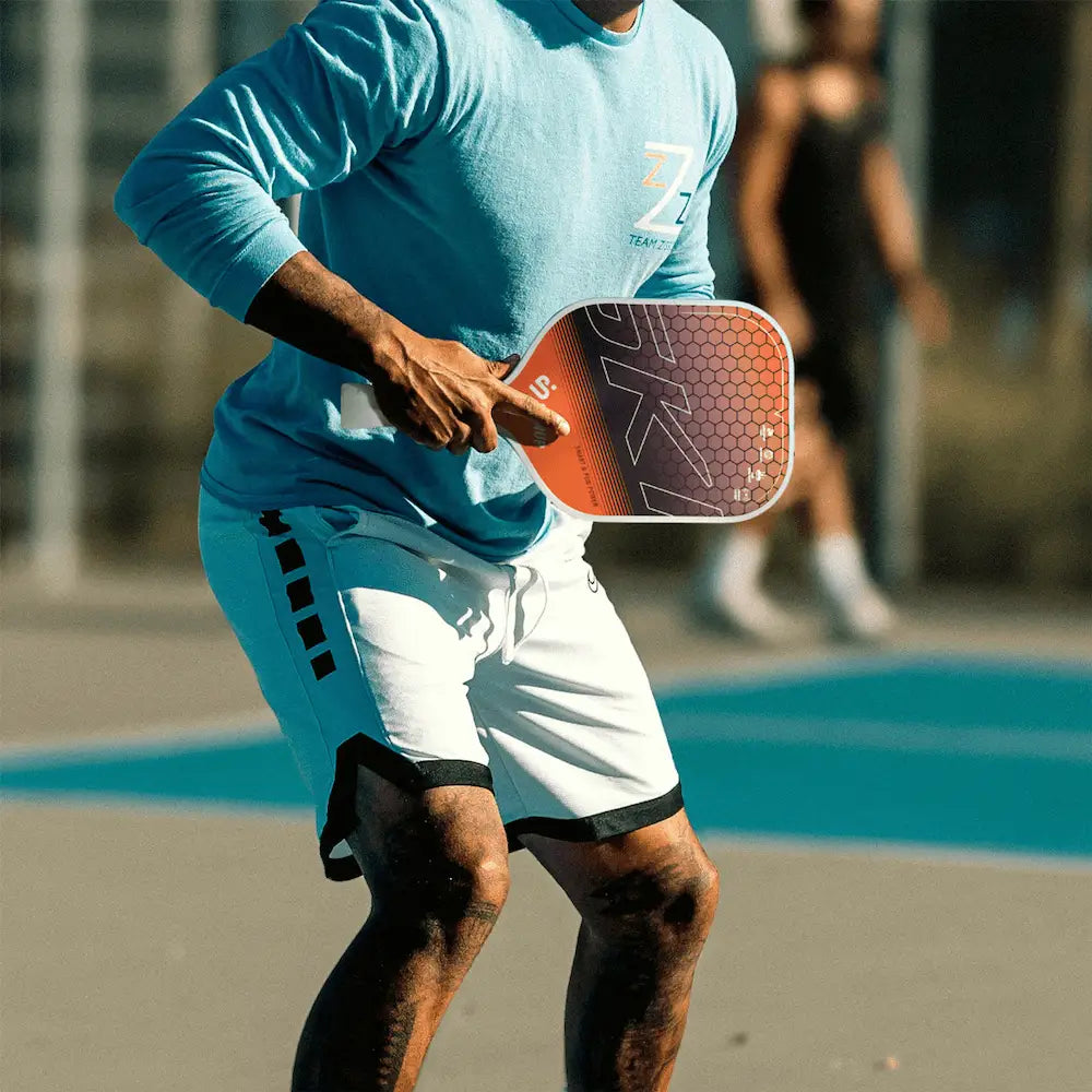 Raquette SKINUP SPORT Smart & Fun + orange en match – joueur en action